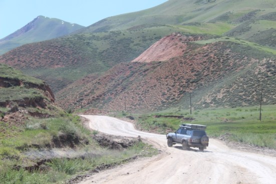 Jon swerves his truck (Boris) to avoid yet another crater in the road