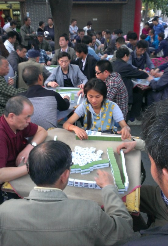 Mahjong games are played on the street all day